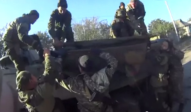 Военные Новороссии вывозят своего раненого бойца под обстрелом (видеосюжет)