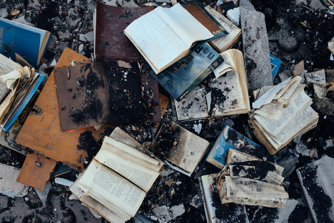 Книги рядом с руинами частного дома в поселке Кондратьевка Донецкой области, разрушенного ракетой из БМ-21 «Град».